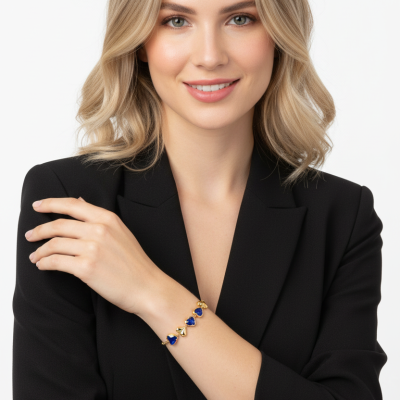Mulher com pulseira de metal dourado e pedras azuis em formato de coração no pulso