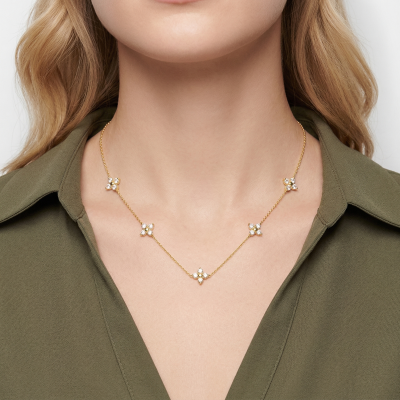 Colar dourado com cinco flores de pedras brilhantes usado ao pescoço