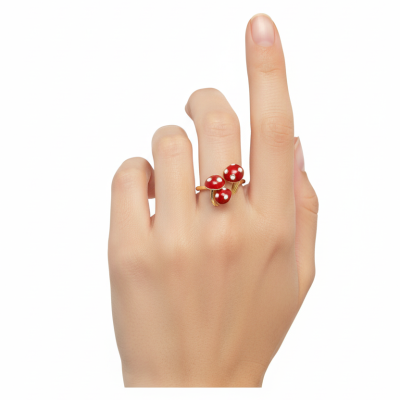 Anel dourado com três cogumelos vermelhos em mão feminina