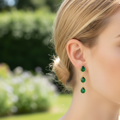 Brincos de gemas verdes em forma de gota com moldura dourada