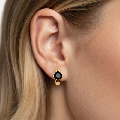 Brinco dourado com pedra preta na orelha de uma mulher