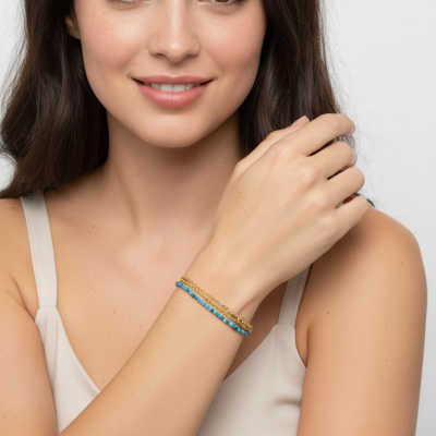 Pulseiras azuis e douradas no pulso esquerdo de mulher com top bege