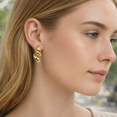 Brincos dourados espiral em mulher com cabelo loiro ao ar livre