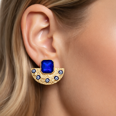 Brinco dourado texturizado com pedra azul quadrada e detalhes em círculos azuis e brancos.