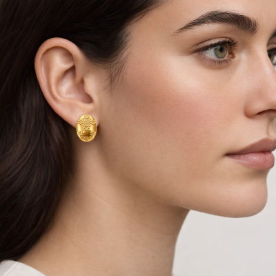 Brinco dourado oval com detalhes entrelaçados norelha de mulher