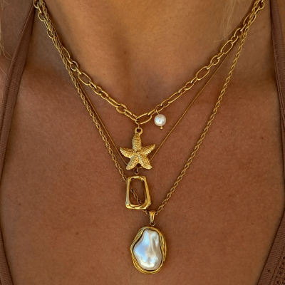 Colar dourado com pendentes de estrela-do-mar, pérola e madrepérola.
