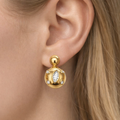 Brinco dourado com pedras brilhantes na orelha