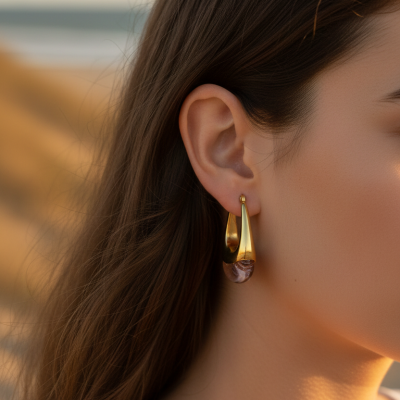 Brinco pendente dourado com pedra rosa em mulher