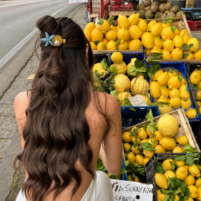 Banca de rua com limões amarelos em caixas, com placas de preço e texto em italiano.