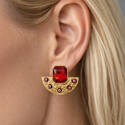 Brinco dourado com pedra vermelha retangular no centro em orelha de mulher
