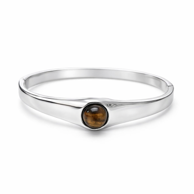 Pulseira de metal prateado com pedra castanha redonda no centro