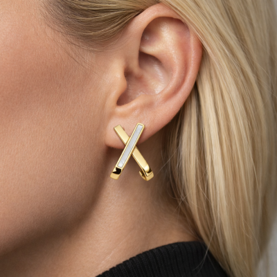 Brinco dourado em forma de X na orelha de mulher