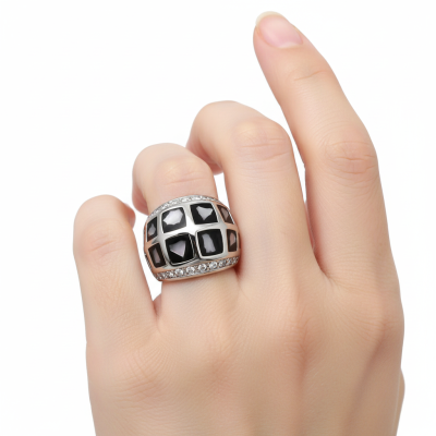 Anel prateado largo com pedras pretas quadradas e cristais pequenos em fundo branco.