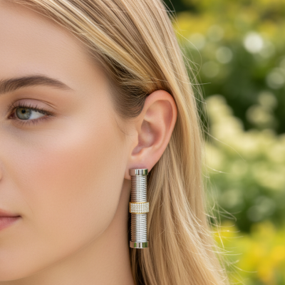 Brinco pendente prateado com detalhes dourados em mulher loira.