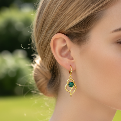 Brinco dourado com pedra verde na orelha de mulher