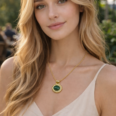 Colar feminino com pedra verde e dourado usado por mulher com vestido bege
