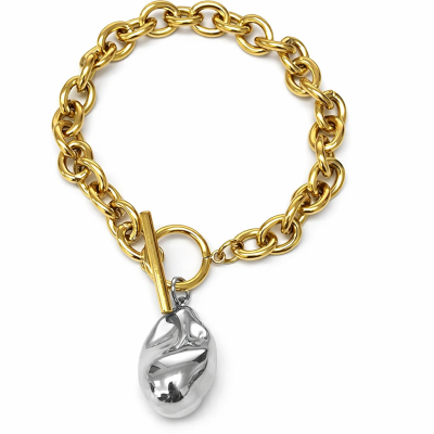 Pulseira de corrente dourada com pendente prateado em fundo branco