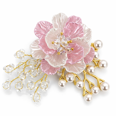 Broche decorativo em forma de flor com pétalas rosa e branco perolado, cristais e pérolas em arcos dourados.