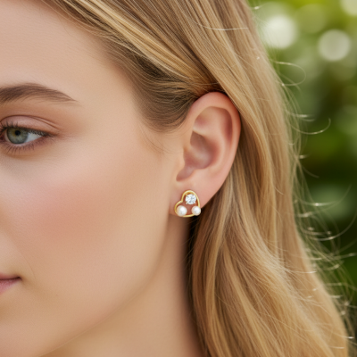 Brincos de coração dourados com pérolas e pedra brilhante na orelha de mulher loira