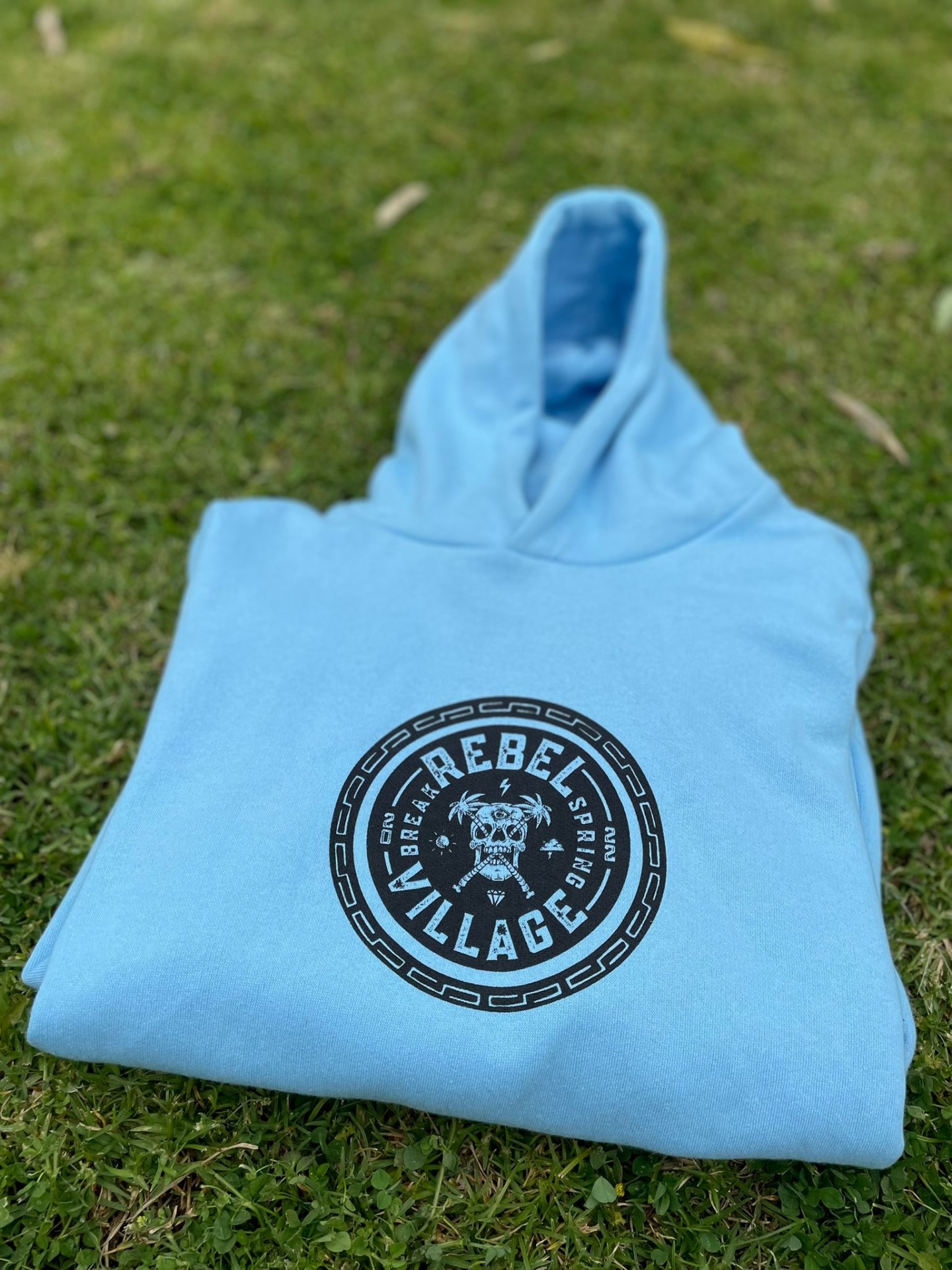 Sweatshirt azul clara dobrada com capuz e estampado circular preto no centro