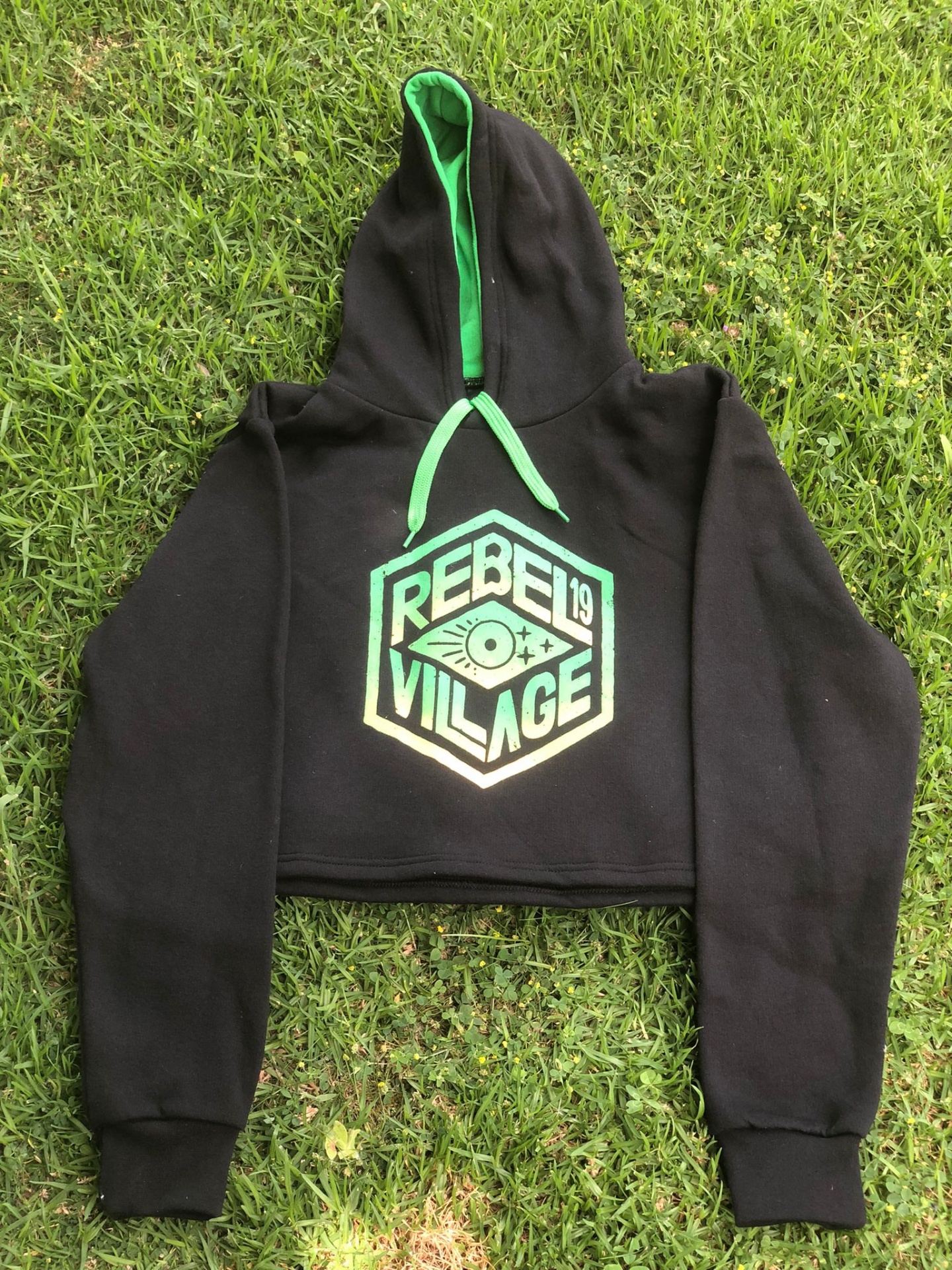 Sweatshirt cropped preta com capuz e estampa REBEL VILLAGE sobre relva