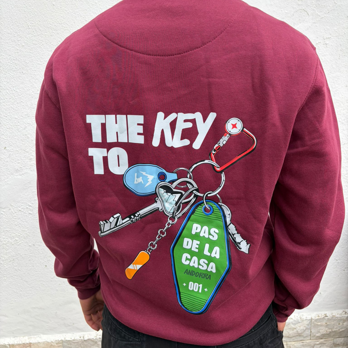 Sweatshirt vinho com estampa de chaveiro e texto nas costas