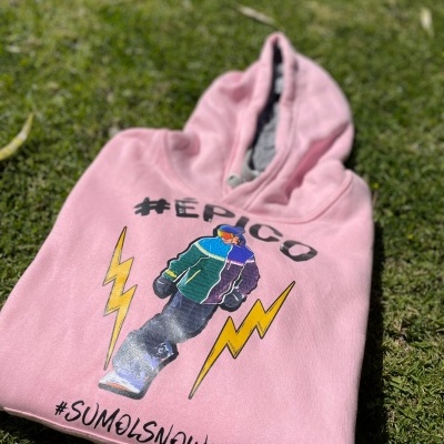 Camisola cor-de-rosa com capuz e estampa colorida sobre relva verde