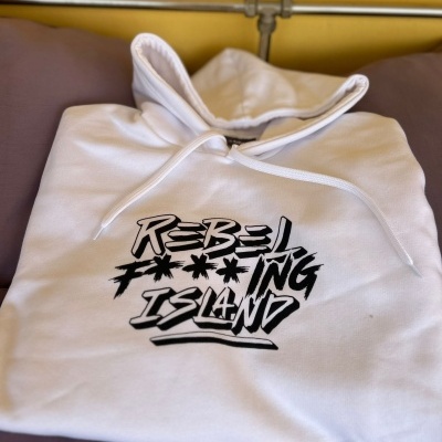 Hoodie branco com capuz e estampa preta REBEL F***ING ISLAND sobre almofadas castanhas e roxas