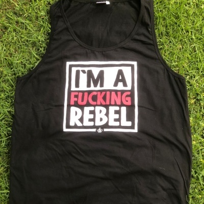 Camisola preta sem mangas com estampa em branco e vermelho I'M A FUCKING REBEL sobre relva.