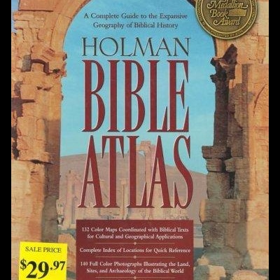 Capa do livro HOLMAN BIBLE ATLAS com ruínas, selo dourado e etiquetas de preço amarelas