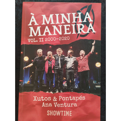 Capa de livro vermelha com grupo de cinco homens no palco e texto branco