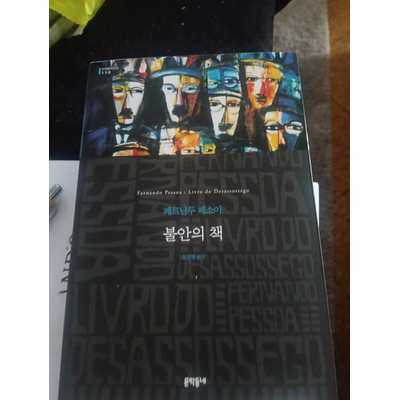 Capa de livro preta com rostos coloridos e texto em coreano e português