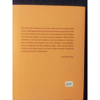 Capa traseira de livro laranja com texto e etiqueta de preço 23€