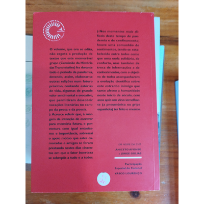 Parte de trás de livro vermelho com texto em português e logotipo branco sobre mesa de madeira