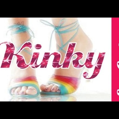 Pés femininos com sandálias de tiras azuis e sola arco-íris com texto Kinky e faixa Sex Coupons