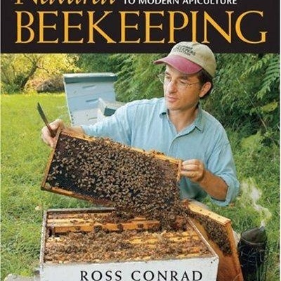 Capa livro apicultura com homem a manusear colmeia com abelhas ao ar livre