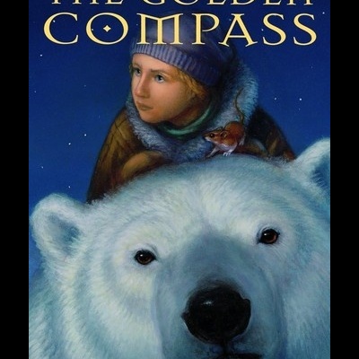 Capa do livro The Golden Compass com um urso polar branco e uma criança com chapéu azul
