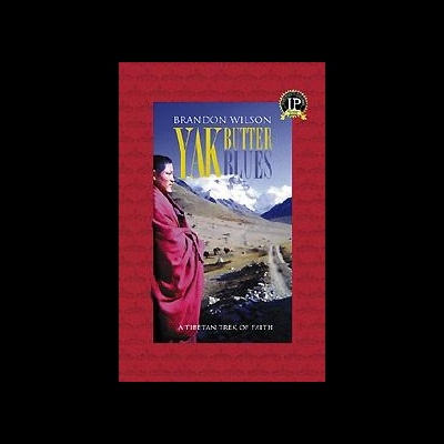 Capa do livro Yak Butter Blues com mulher em roupa vermelha e montanhas nevadas
