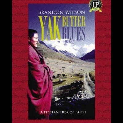 Capa do livro Yak Butter Blues com paisagem montanhosa e pessoa com roupa vermelha