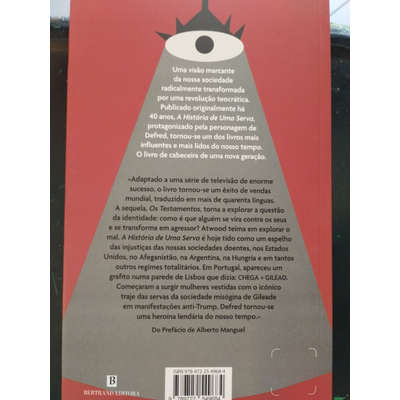 Parte traseira de um livro com design triangular cinzento, olho preto e texto em português