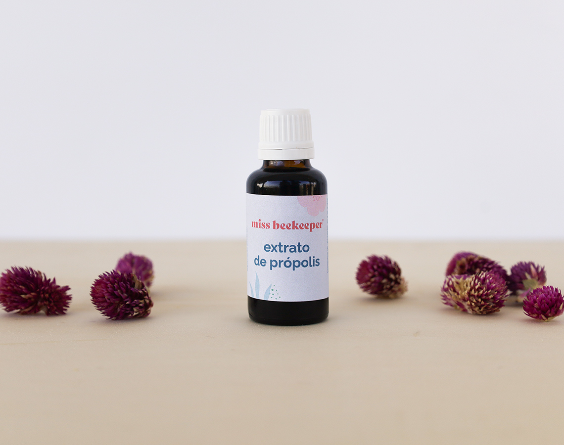 Frasco de extrato de própolis com flores secas roxas