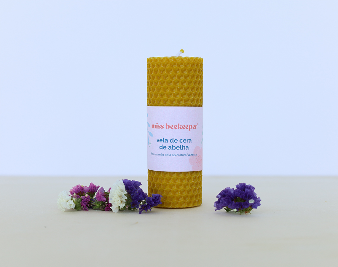 Vela de cera de abelha amarela com rótulo e flores decorativas