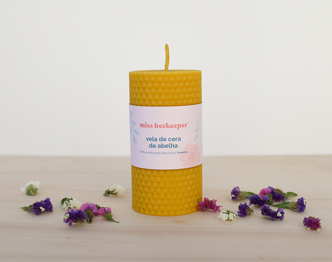 Vela de cera de abelha amarela com etiqueta miss beekeeper e flores secas