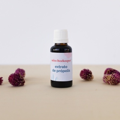 Frasco de extrato de própolis com flores secas roxas