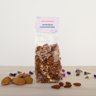 Pacote transparente de amêndoas caramelizadas com etiqueta 'miss beckeeper amêndoas caramelizadas'