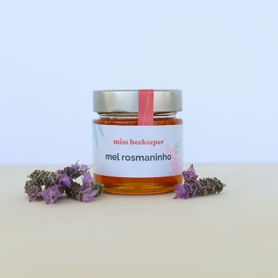 Frasco de mel de rosmaninho com raminhos de flores roxas
