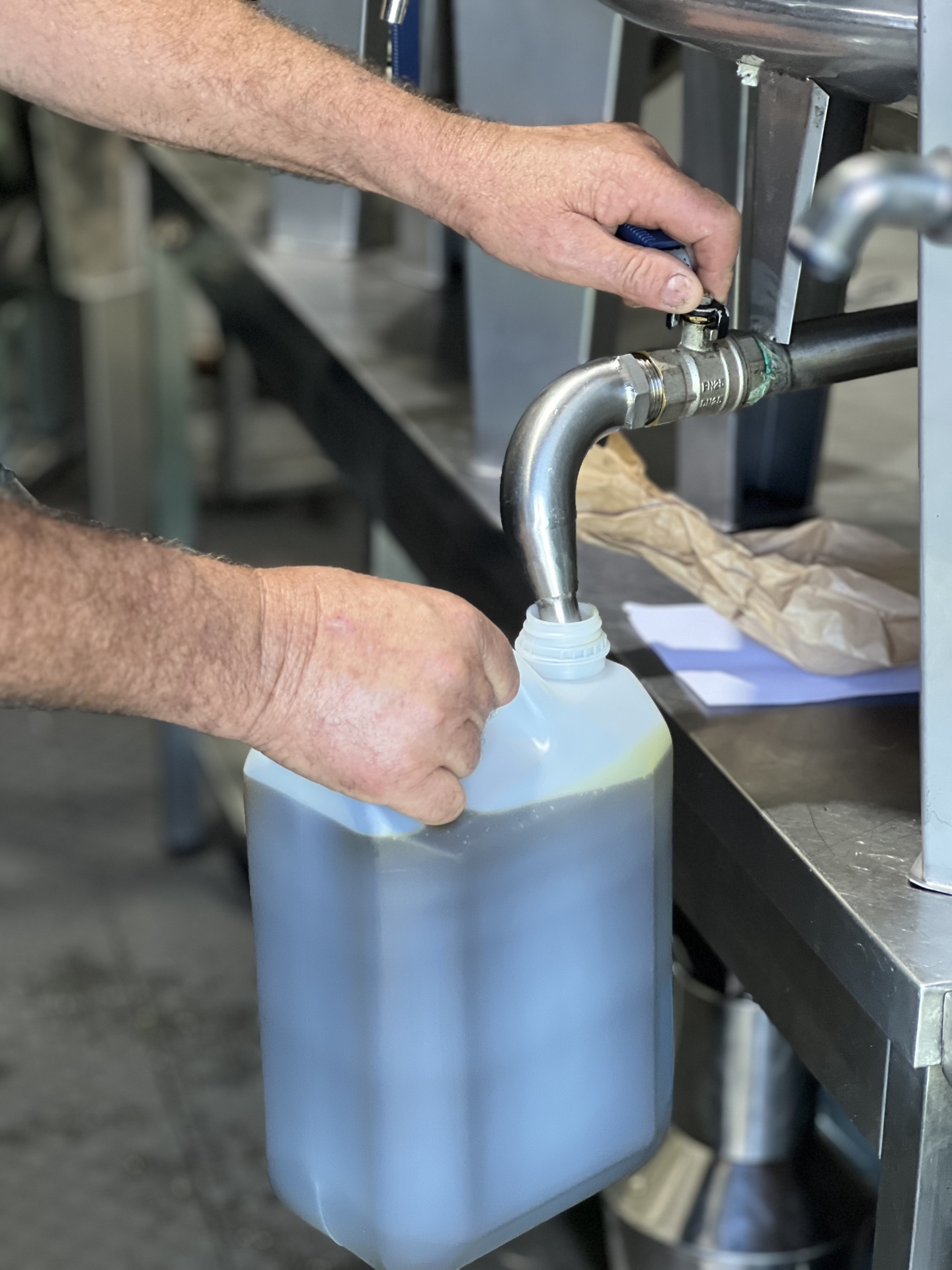 Encher recipiente plástico com líquido em ambiente industrial