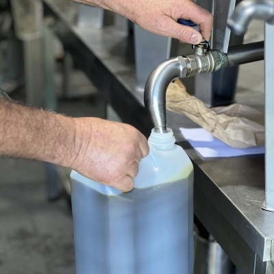 Encher recipiente plástico com líquido em ambiente industrial