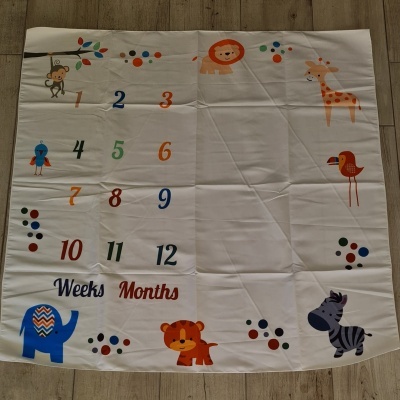 Tecido branco com números coloridos e desenhos de animais para marcação de semanas e meses