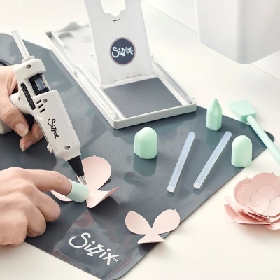Pistola de cola quente e acessórios Sizzix com recortes de papel em formato de flor
